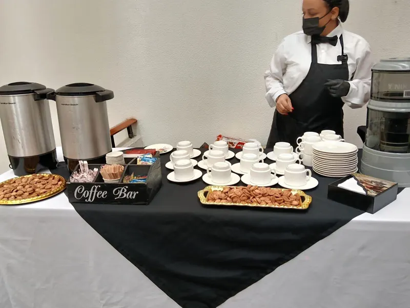 Estación de café atendida por meseros en un evento
